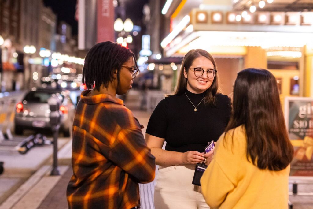 A group of students gathers on the sidewalk on Gay Street in downtown Knoxville