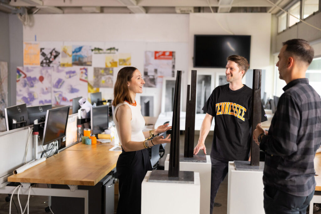 Architecture students have a discussion with a faculty member in an architecture classroom 