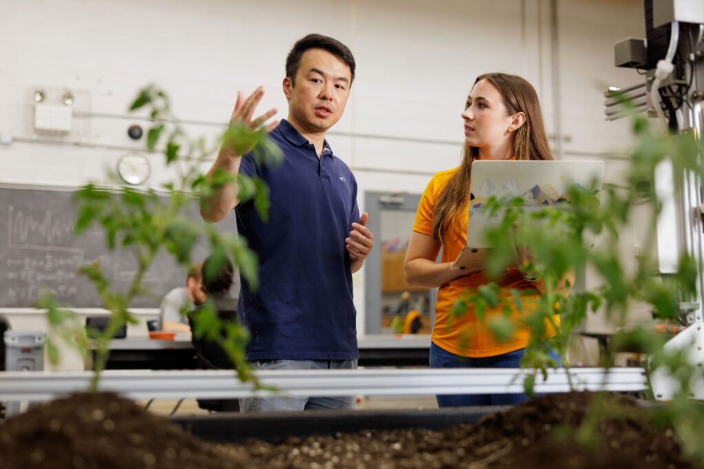 Professor and student work with a farm bot in the Smart Agriculture Lab in the Biosystems Engineering and Soil Science building