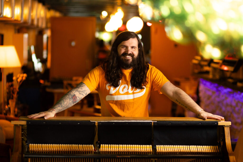 Social worker and Marine veteran Kevin Rumley, a man with long brown hair, a beard, and colorful arm tattoos, wearing an orange Vols t-shirt