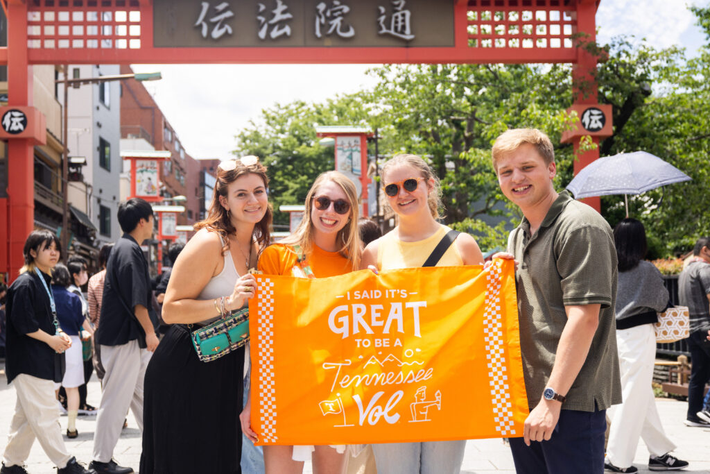 students stand with a flag in an Asian country