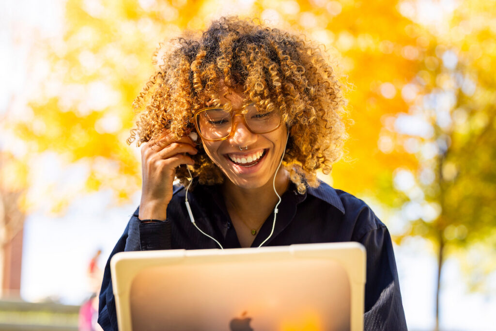 A student studies while relaxing in Humanities Amphitheater surrounded by beautiful fall foliage. Photo by Craig Bisacre, University of Tennessee.